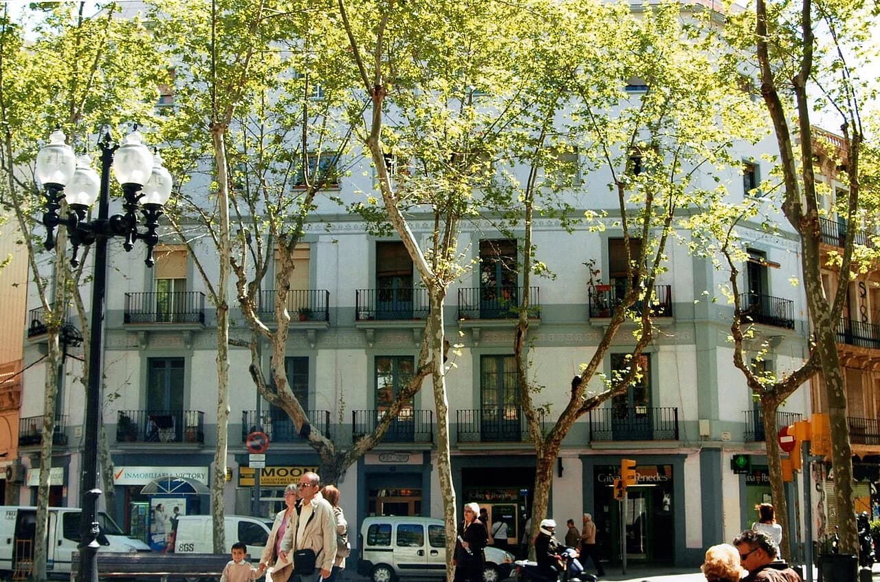 Spring trees, ornate street lamps and balconied apartment buildings along the Rambla del Poblenou, Barcelona