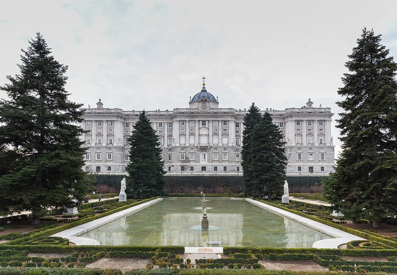 Reflecting pool and conifers in the Sabatini Gardens below the north façade of the Royal Palace, Madrid