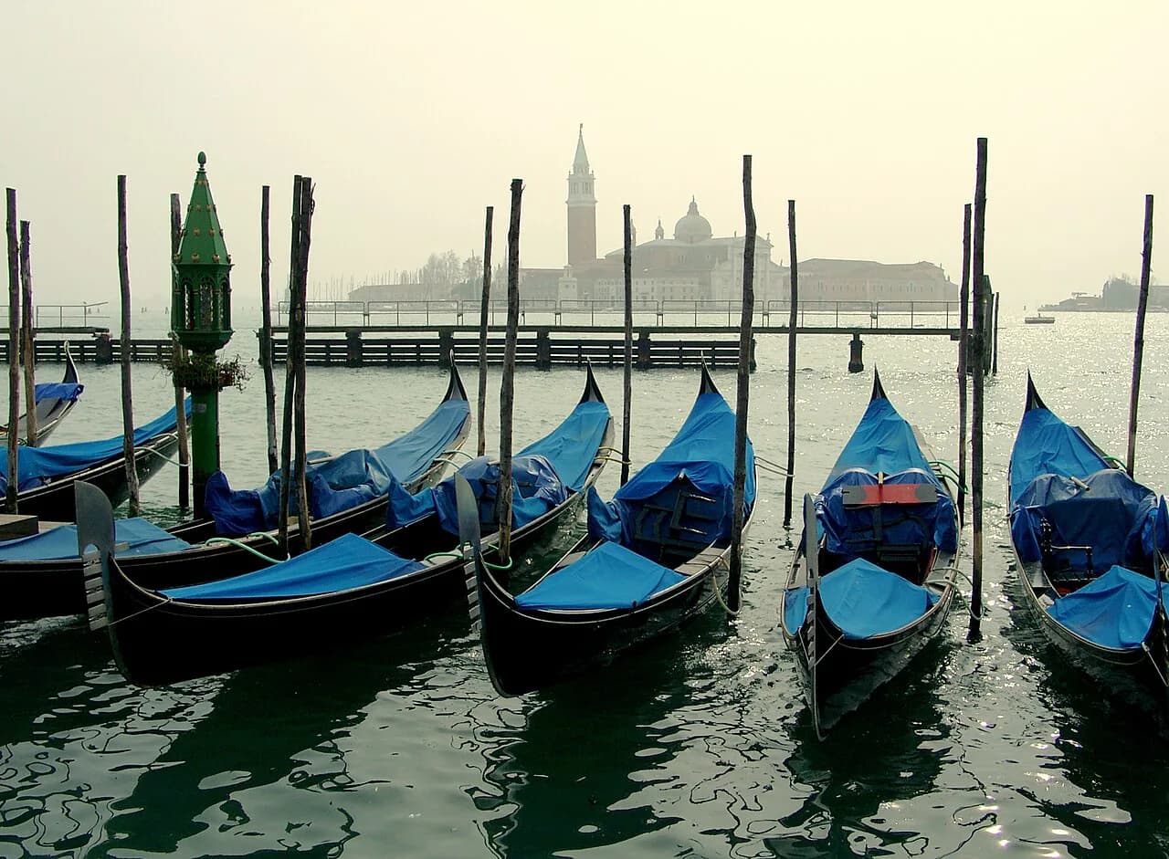 Moored gondolas at San Marco with the church of San Giorgio Maggiore in soft haze across the water, Venice