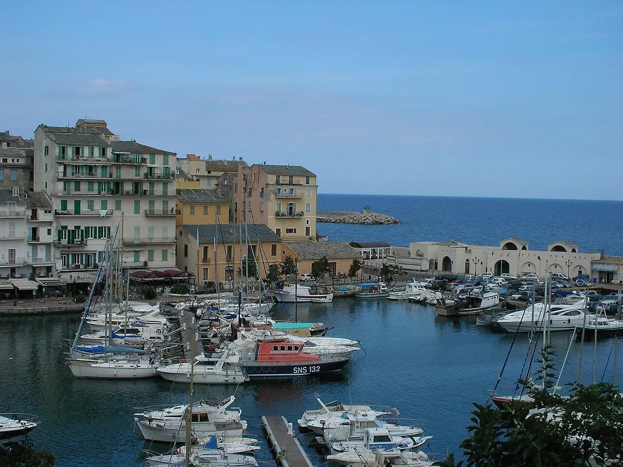 Boats in Bastia's Old Port below tall pastel harbourfront houses, Corsica