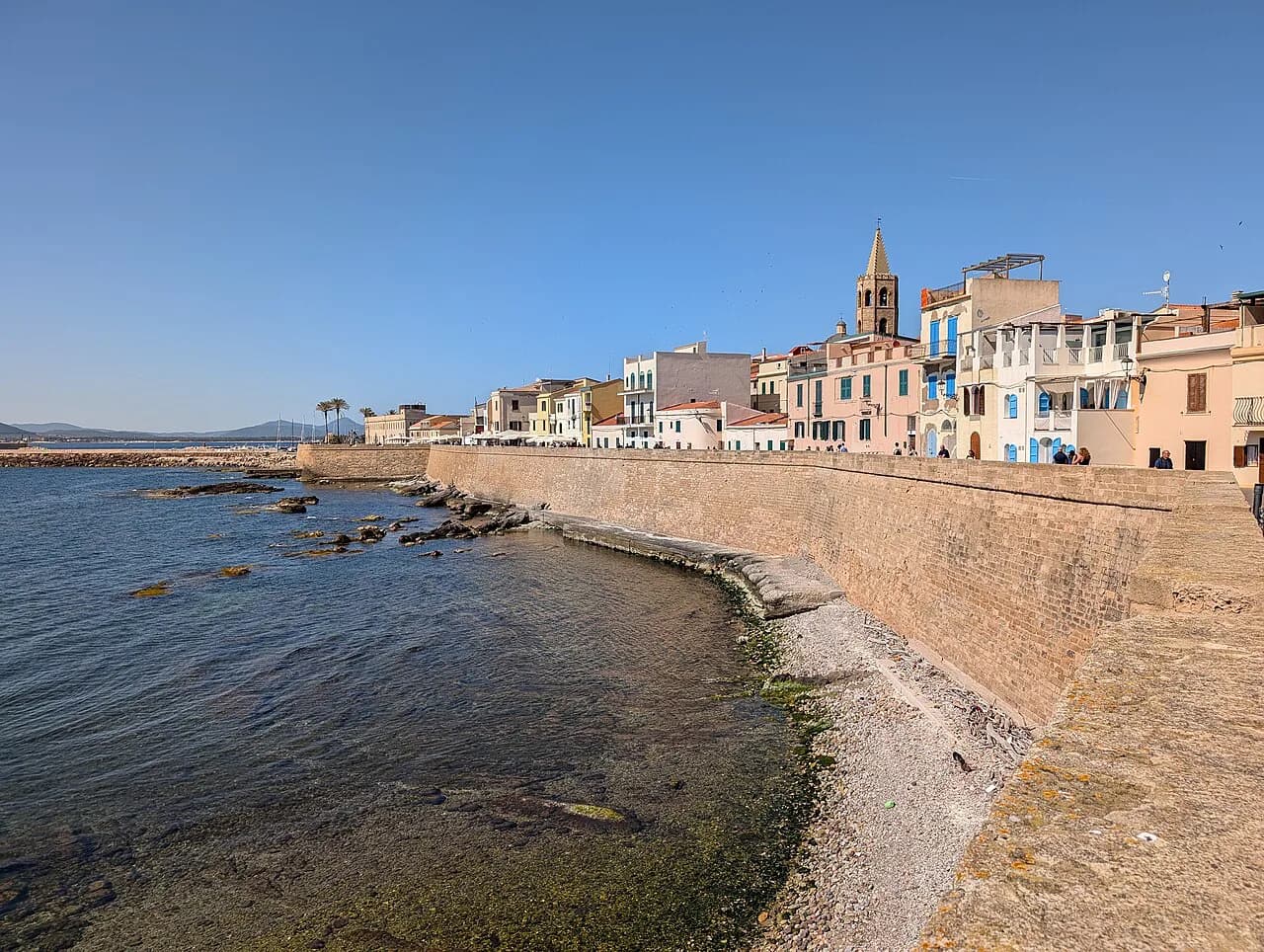 Alghero old town seafront walls and pastel houses along the sea, Sardinia