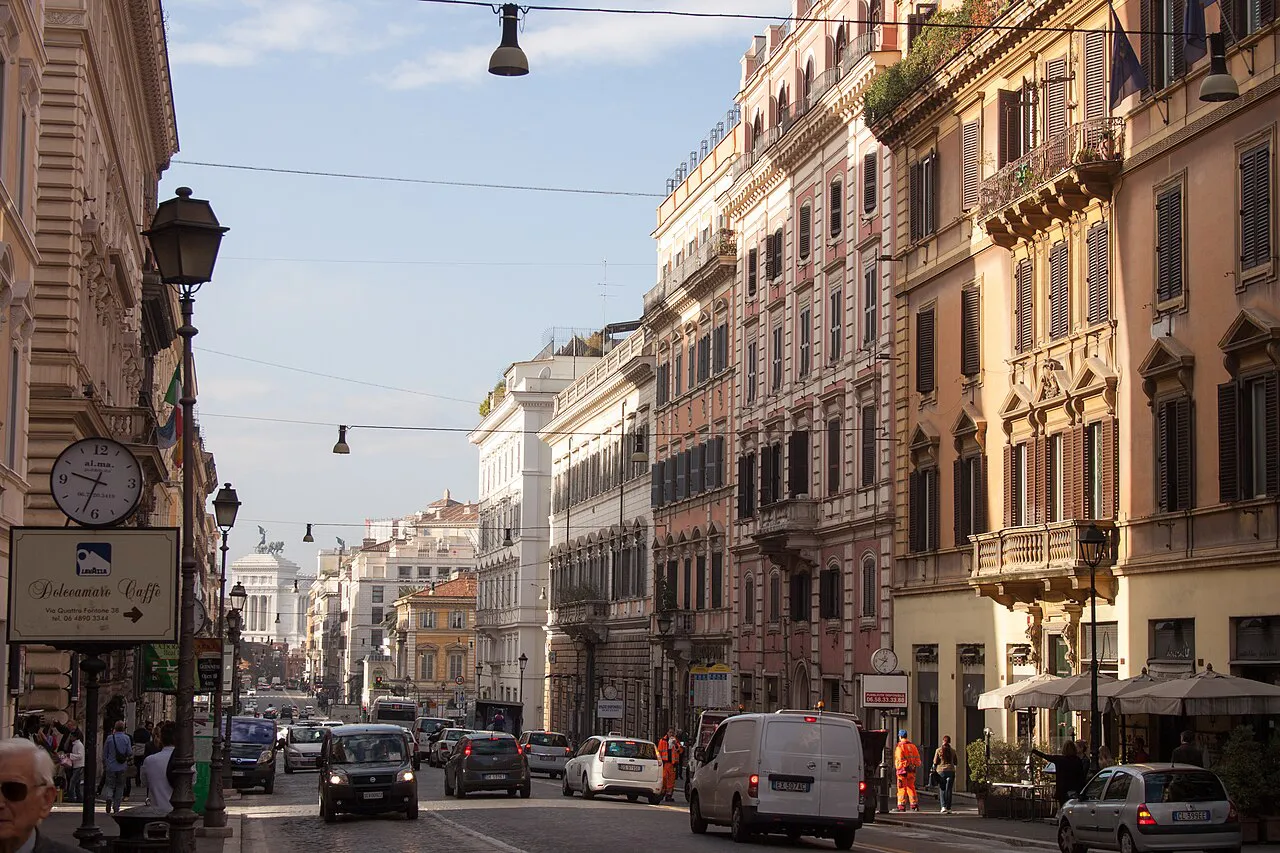 Via Nazionale in Rome lined with tall ornate apartment buildings and street lamps