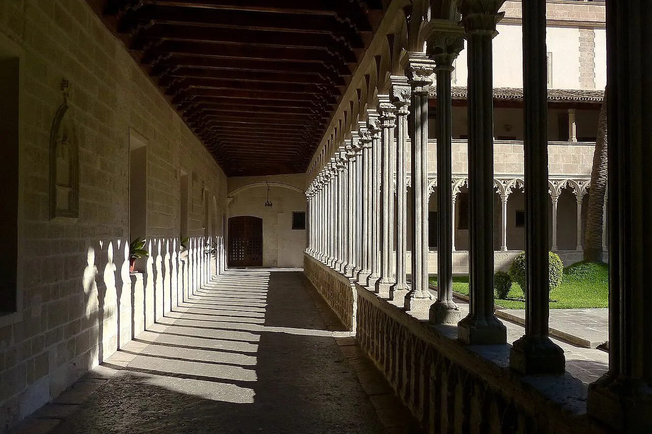 Sunlit Gothic arcade of the cloister at the Basilica of Sant Francesc in Palma