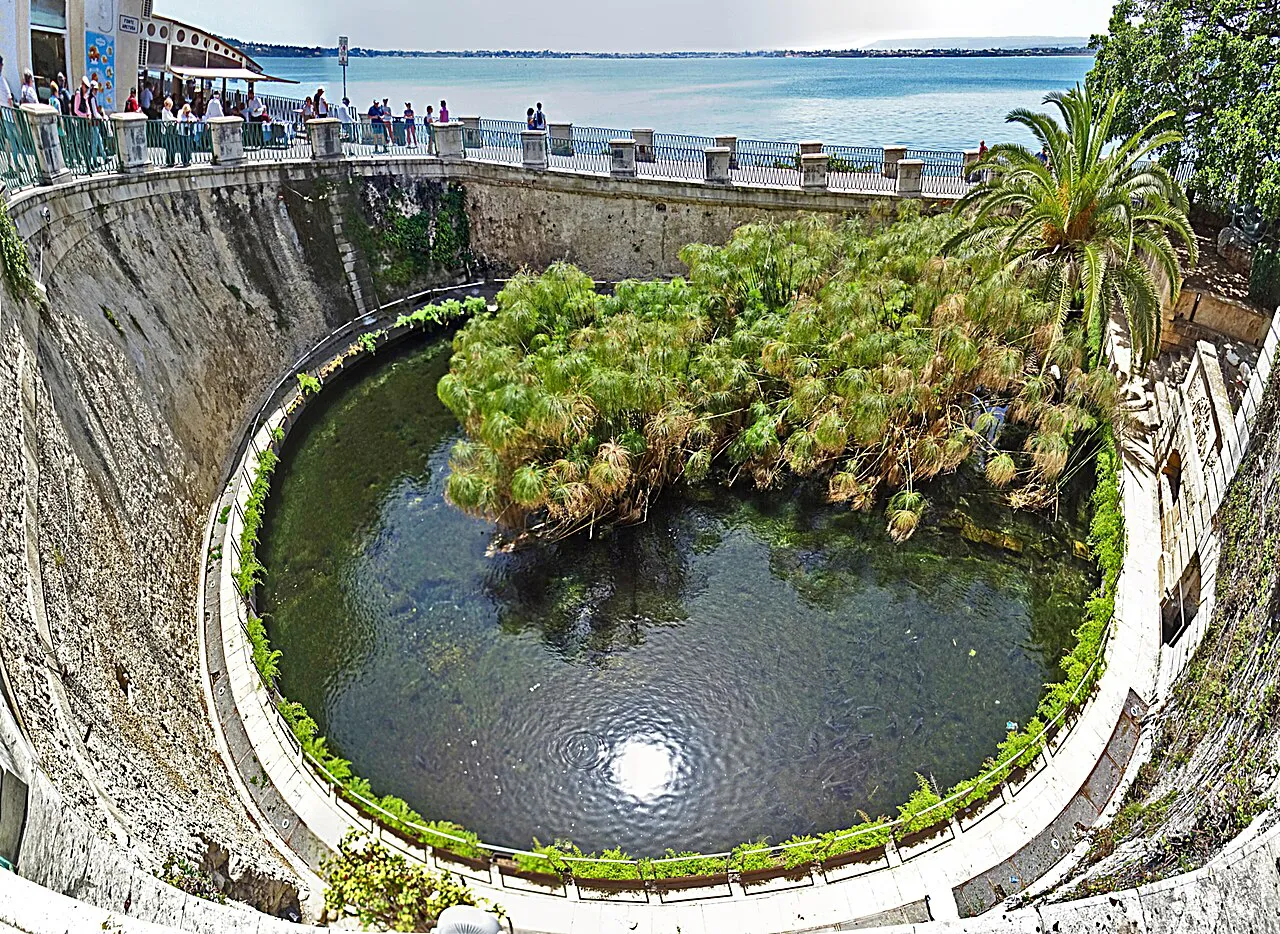 The Fonte Aretusa spring pool with papyrus plants below the seafront promenade in Ortigia