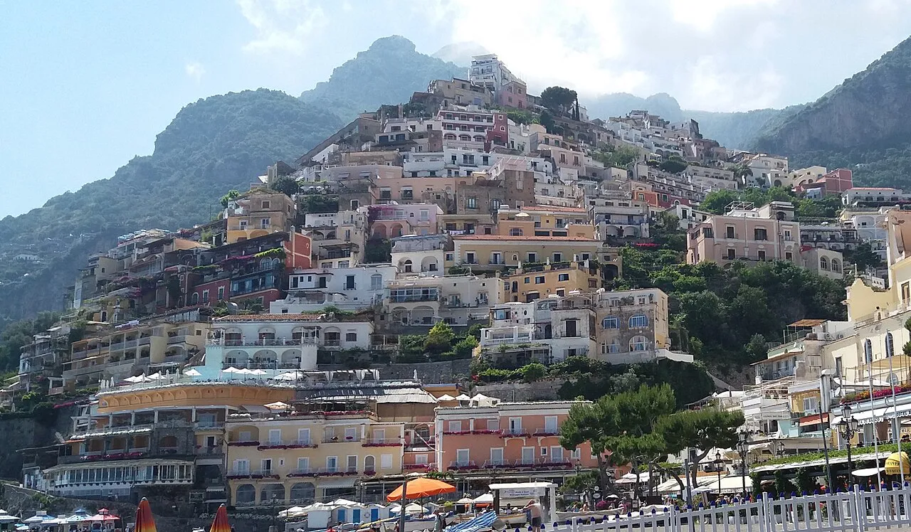 Pastel houses of Positano stacked up the steep hillside, seen from the Spiaggia Grande
