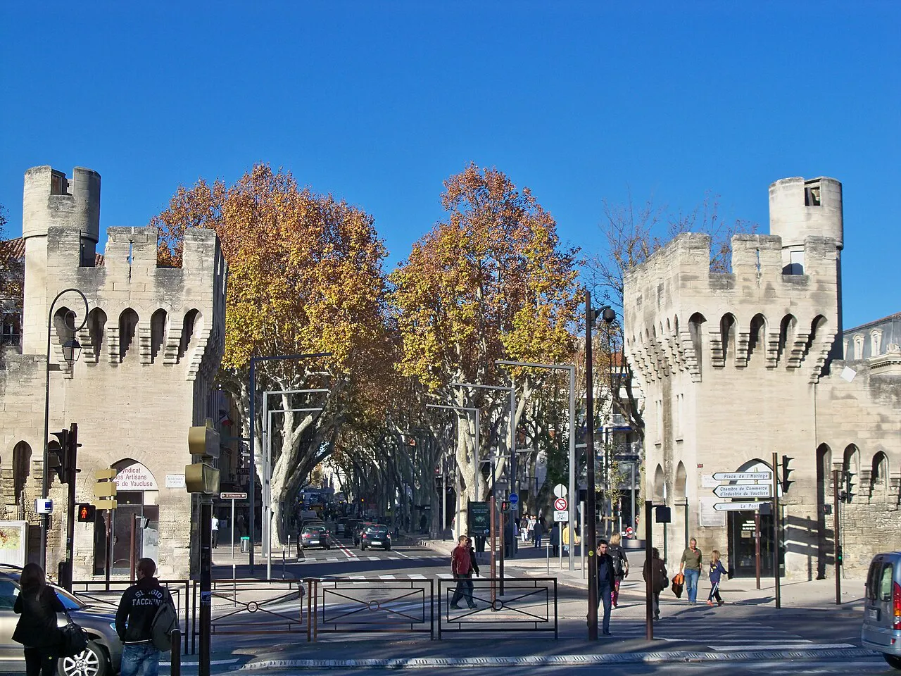 Porte de la République in Avignon’s ramparts, with autumn plane trees lining the avenue beyond