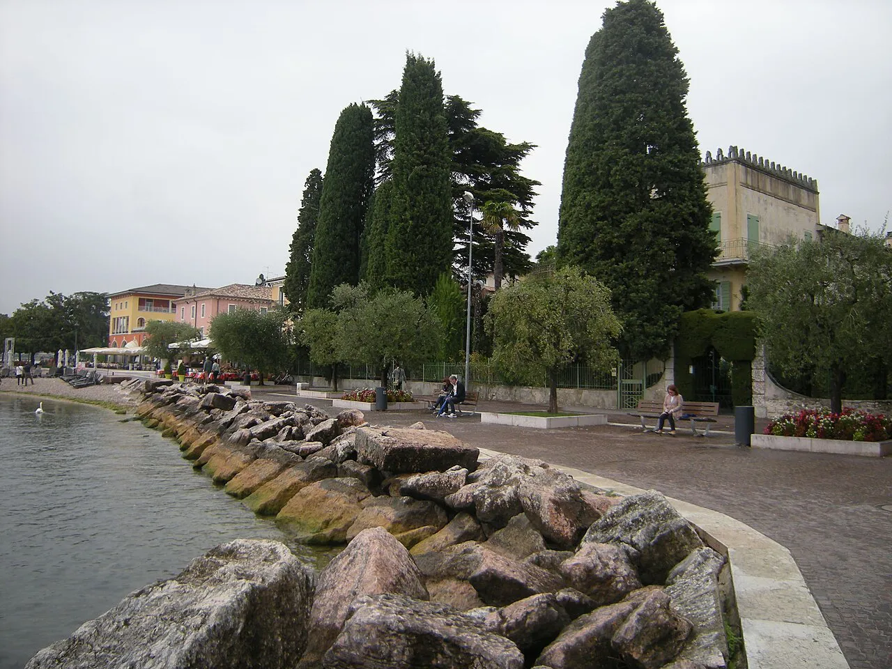 Rock-edged lakeside promenade lined with cypress trees in the hamlet of Cisano di Bardolino, Lake Garda