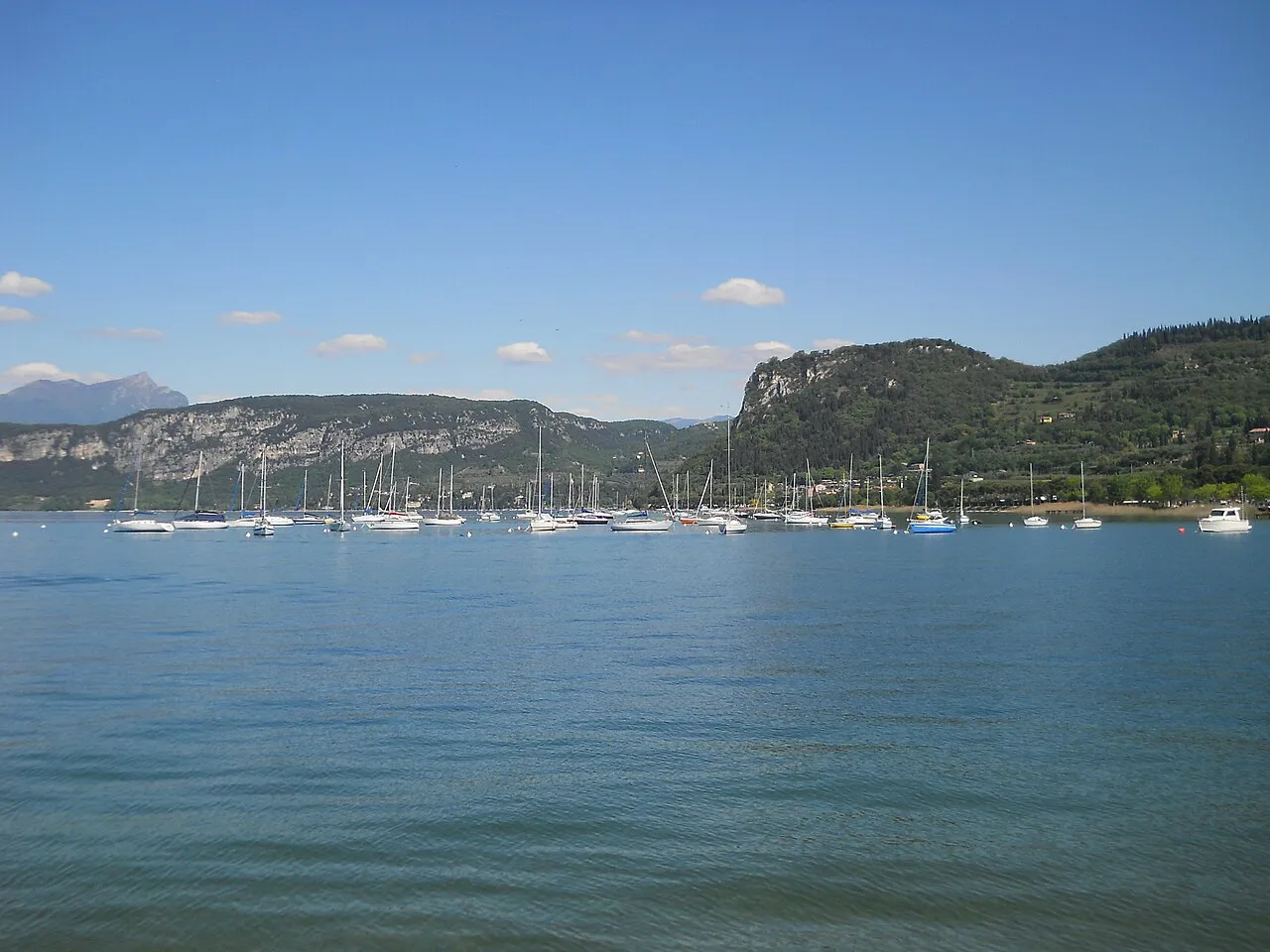 Sailing boats moored off Bardolino with the wooded shores of Lake Garda behind