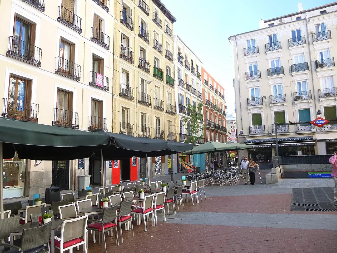 Plaza de Chueca in Madrid with café terraces, tall apartment buildings and the metro entrance