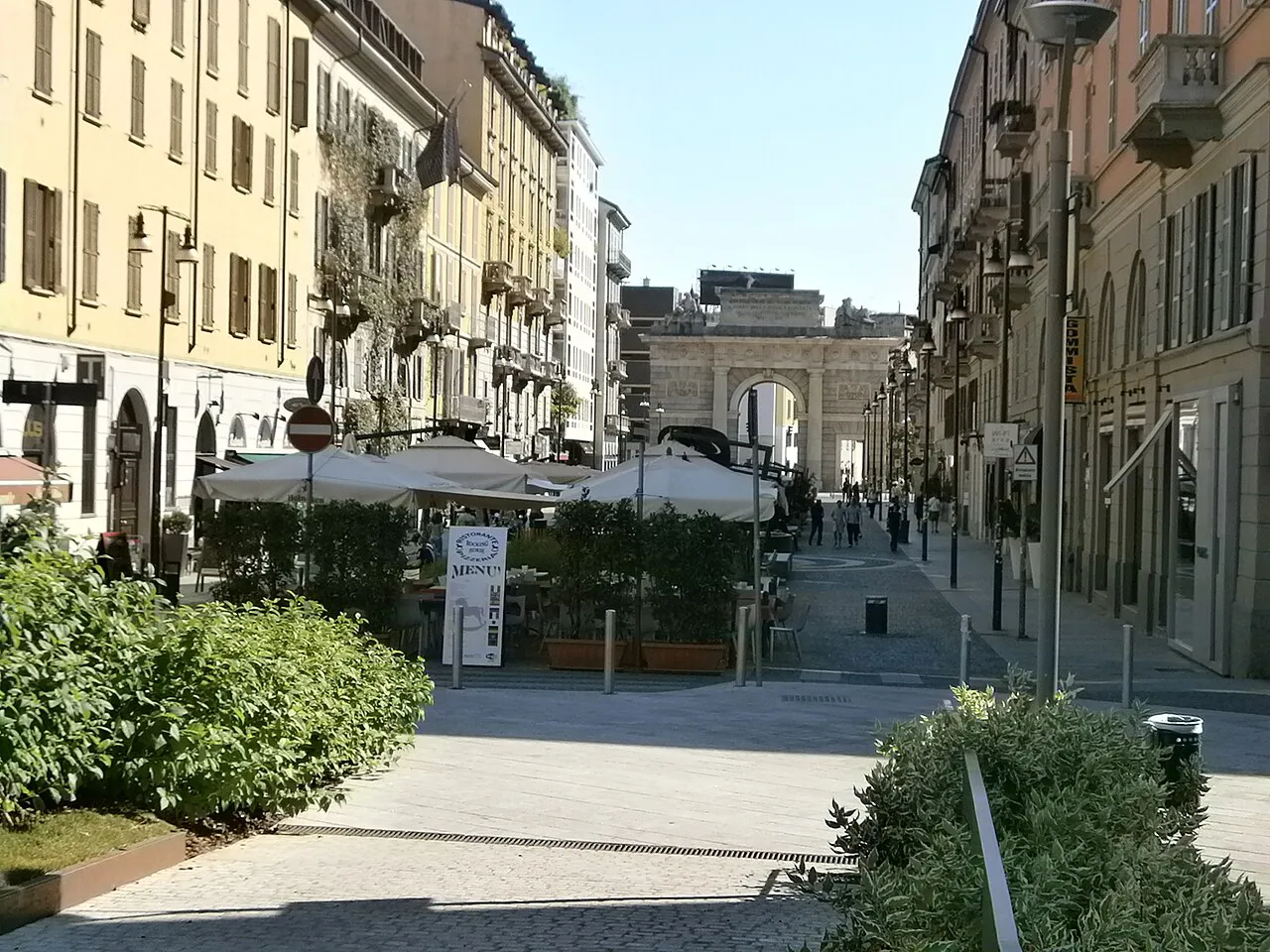 Pedestrianised Corso Como in Milan lined with planters, looking toward the Porta Garibaldi arch