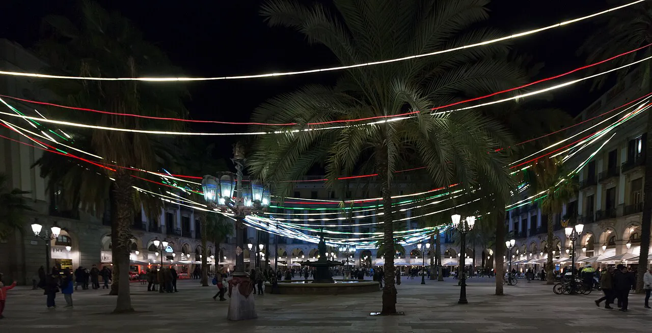 Palm-lined Plaça Reial at night under strings of coloured lights, Barcelona