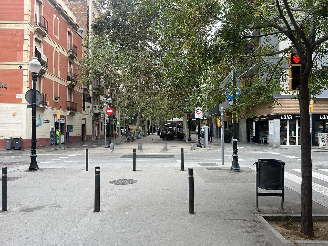Tree-lined pedestrian Rambla del Poblenou with low-rise buildings in Barcelona