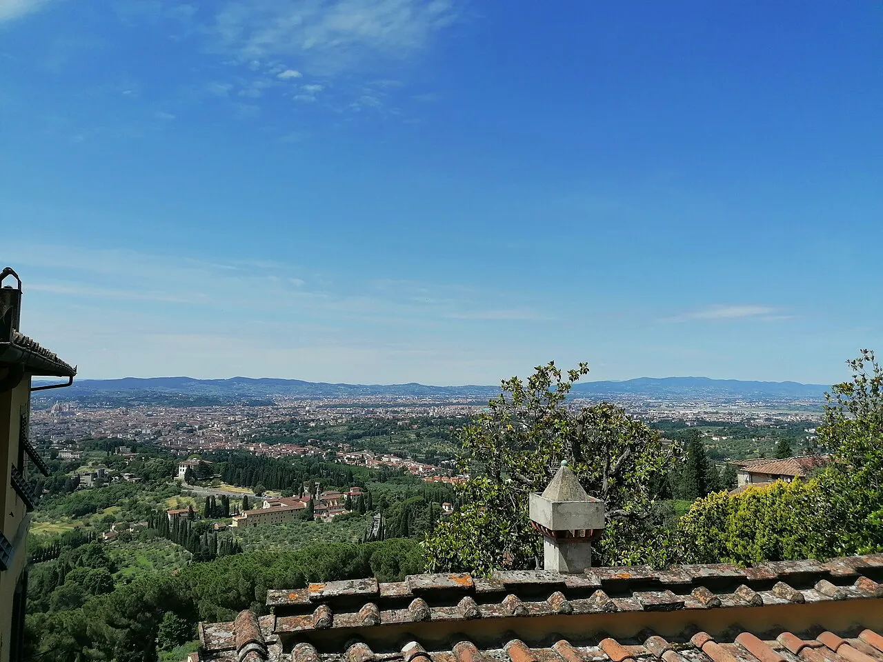 Wooded hillside and the wide Arno valley with Florence in the distance, seen from the road up to Fiesole