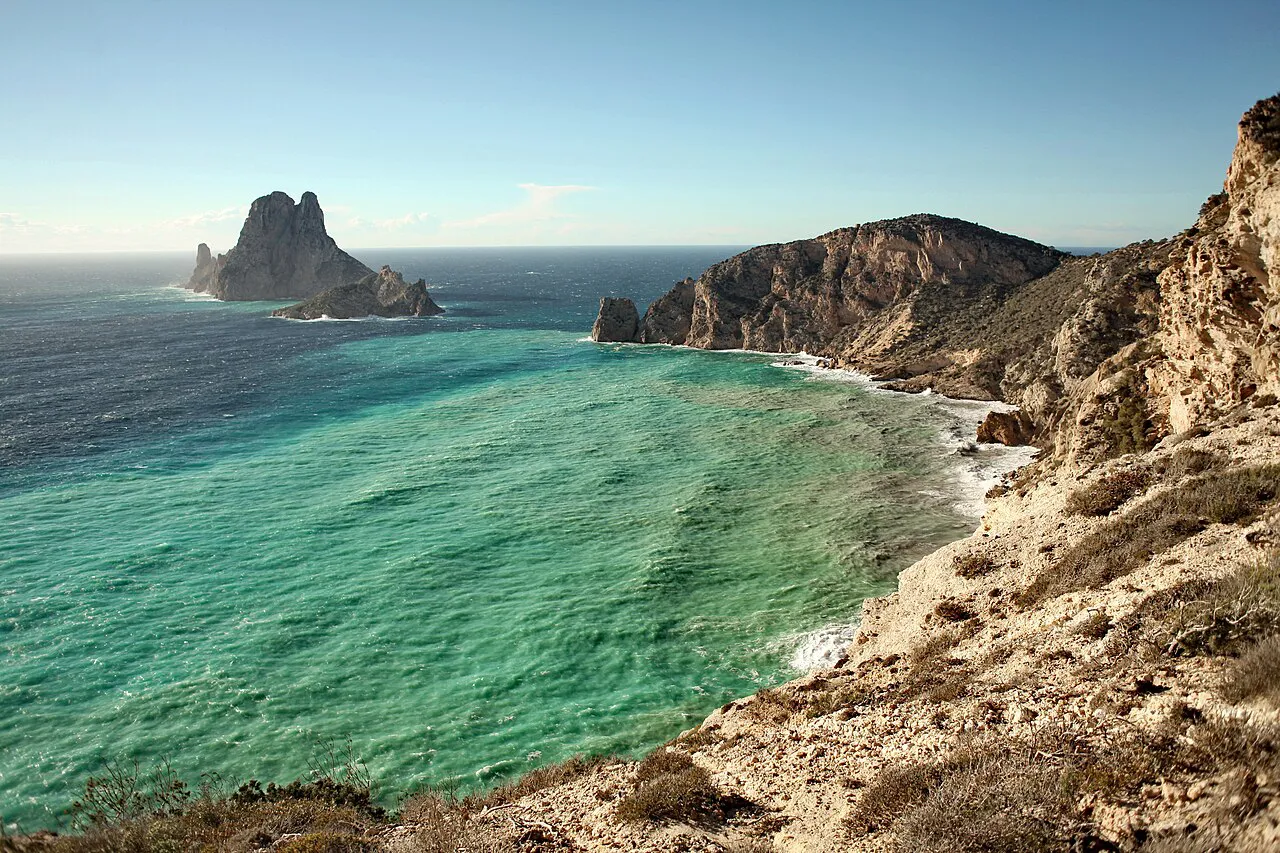 Es Vedrà islet rising from turquoise water beside the cliffs of Ibiza's west coast