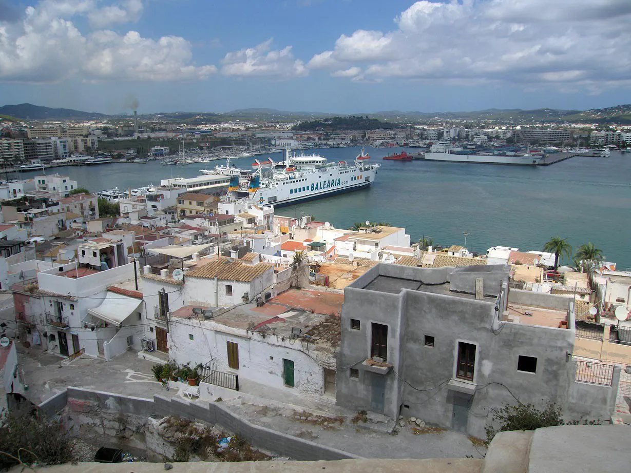 Whitewashed houses of Ibiza's old town looking down over the harbour and ferries