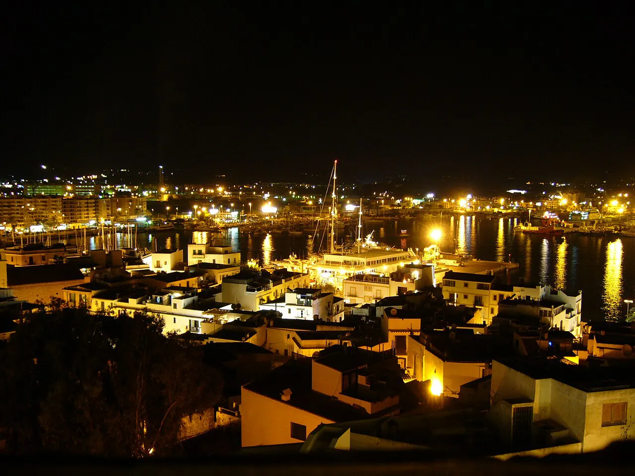 Ibiza Town and its harbour lit up at night, seen from the Dalt Vila ramparts