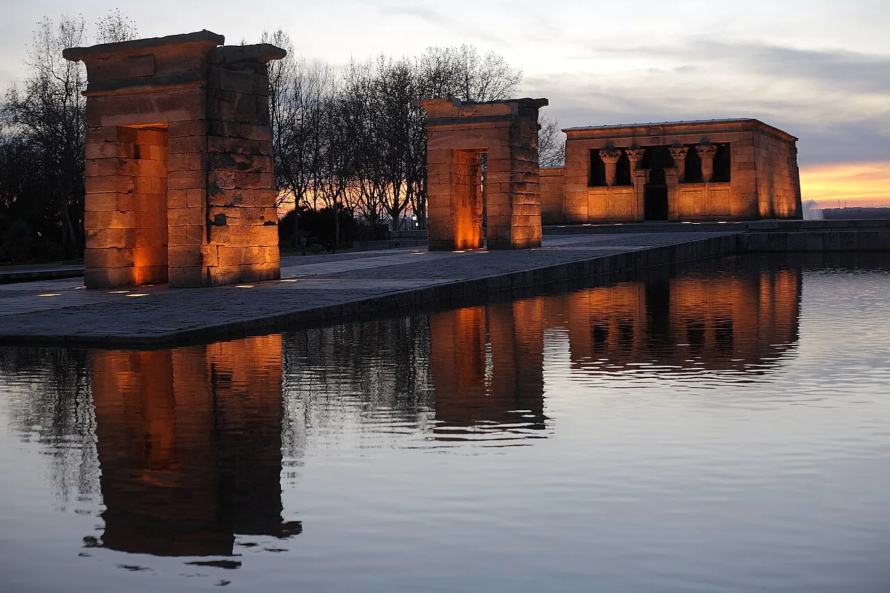 Illuminated Temple of Debod reflected in its pool at dusk in Madrid’s Parque del Oeste