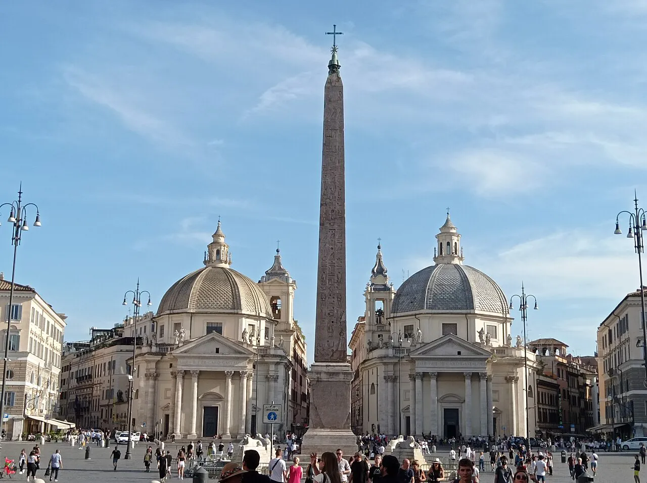 Flaminio obelisk between the twin domed churches of Piazza del Popolo, Rome, under a blue sky
