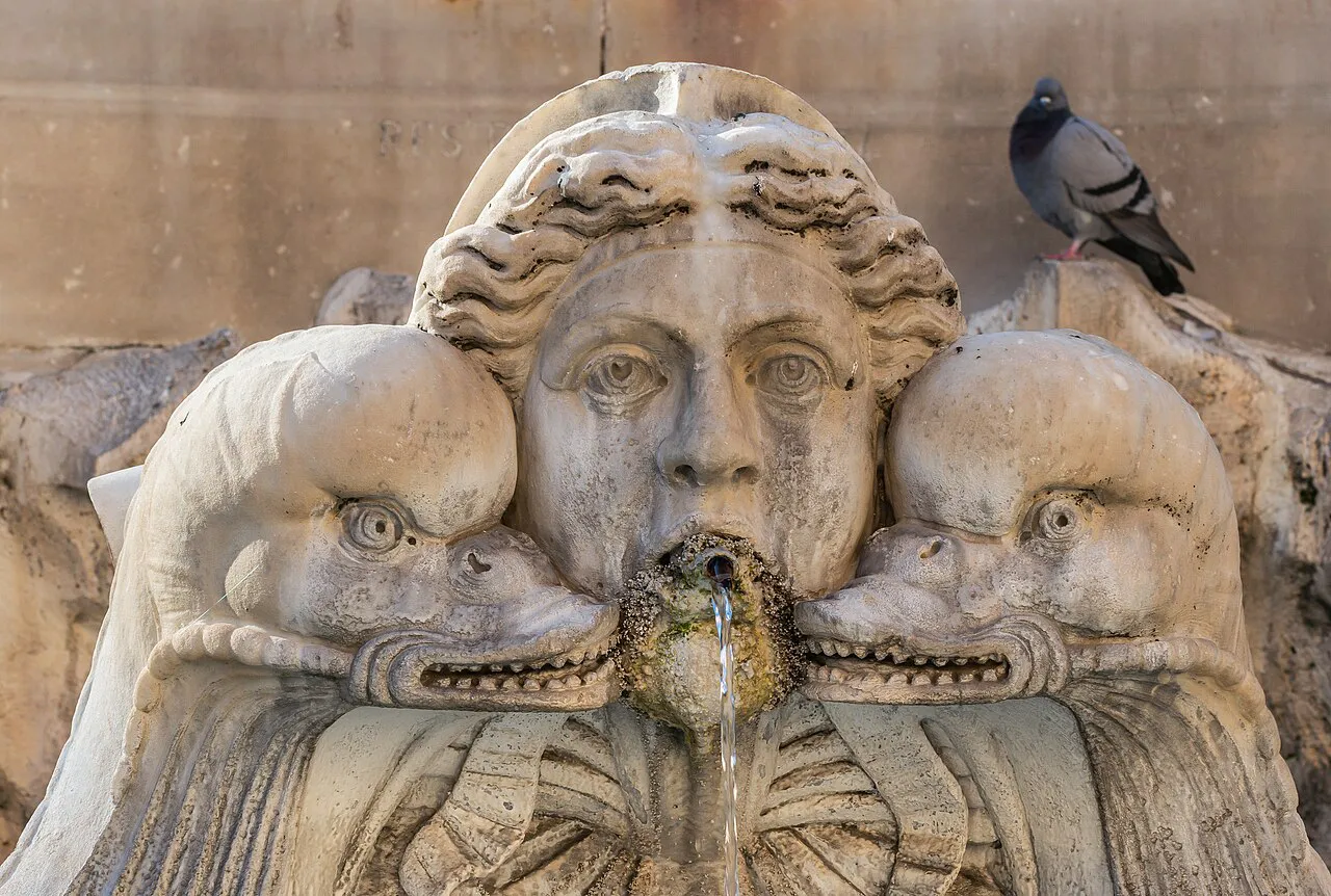 Carved stone mask and dolphins on the fountain in Piazza della Rotonda by the Pantheon, Rome
