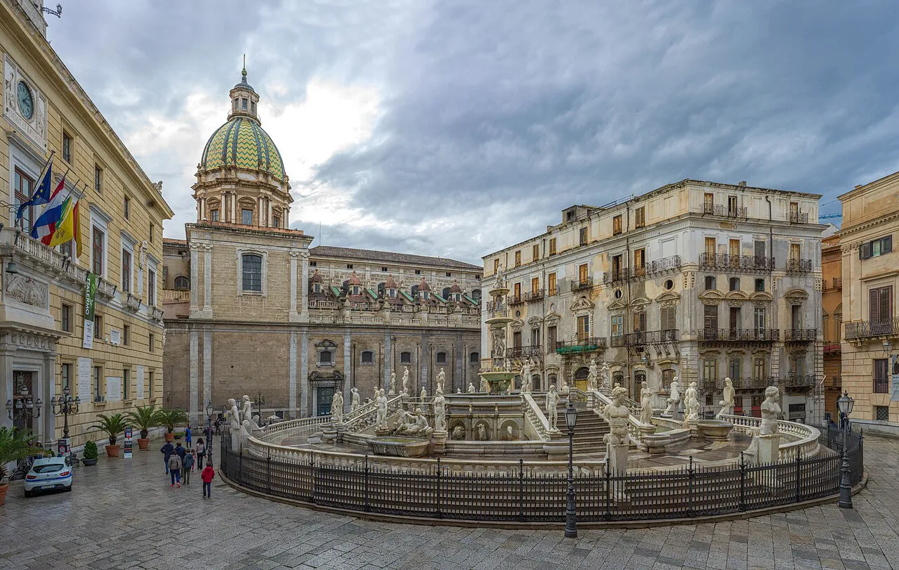 Fontana Pretoria with its marble statues in Piazza Pretoria, Palermo, beneath a church dome