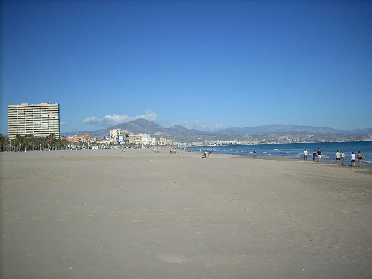 Broad, quiet sands of Playa de Muchavista in El Campello with mountains on the horizon