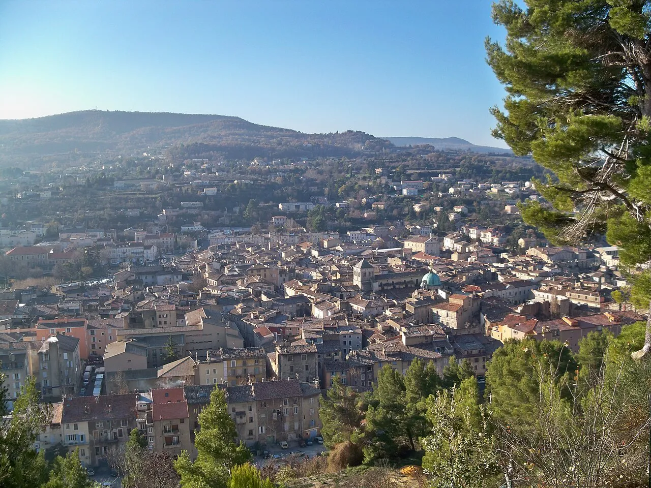 View over the rooftops of Apt in its valley with the Luberon hills beyond