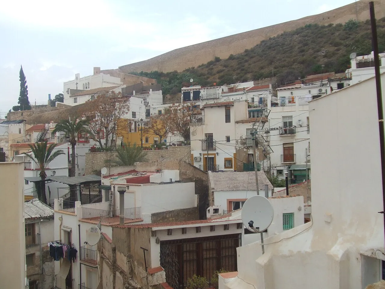 Whitewashed houses of Alicante's Santa Cruz quarter climbing the slopes below Mount Benacantil