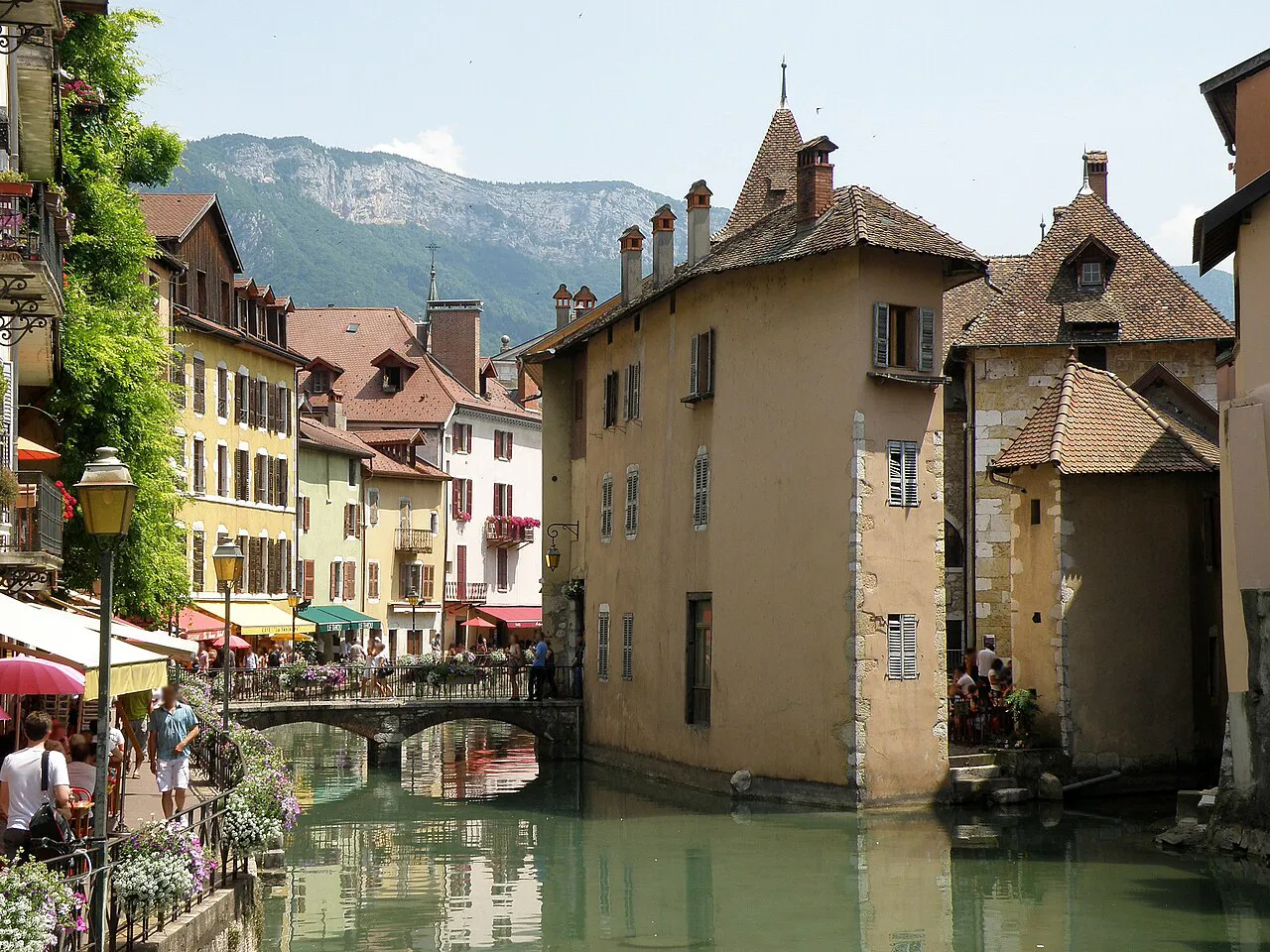 Back of the Palais de l'Isle on the Thiou in Annecy, with old-town houses and mountains behind