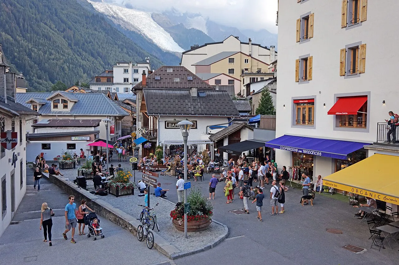 Pedestrian square in Chamonix with cafe awnings, chalet roofs and the Bossons glacier above
