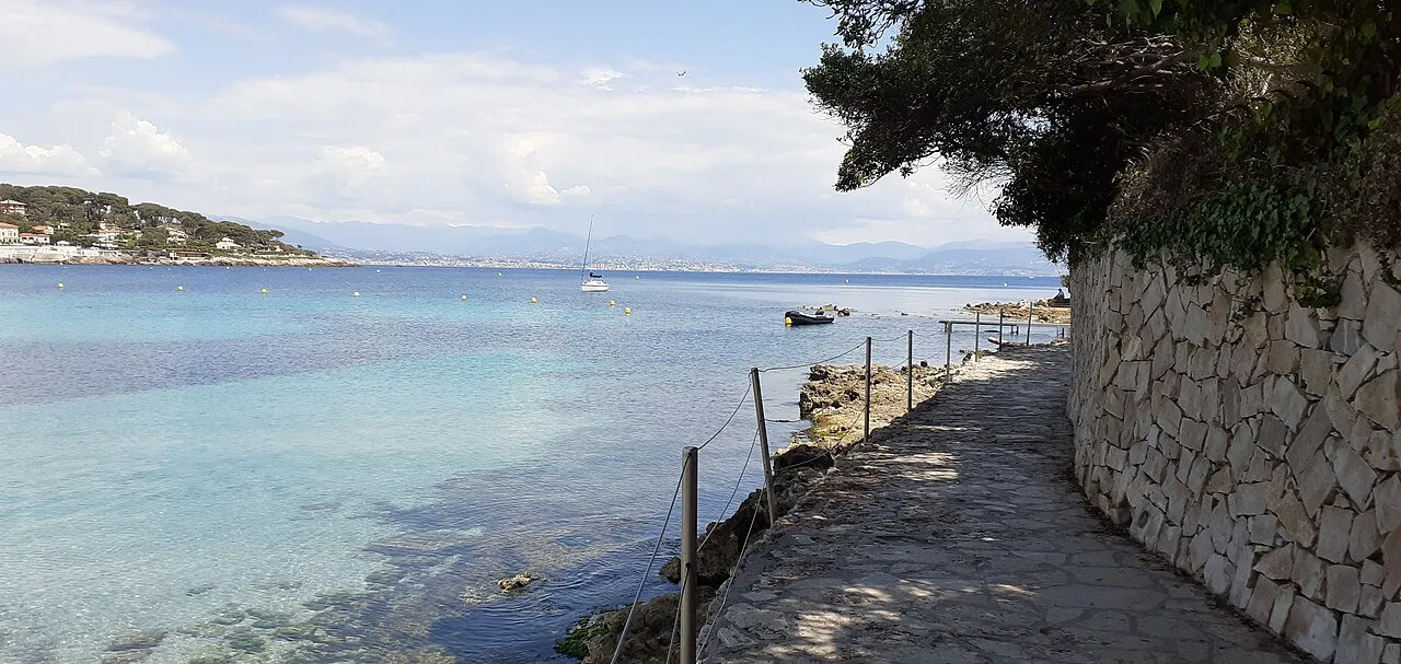 Coastal footpath beside clear turquoise water on Cap d’Antibes, French Riviera