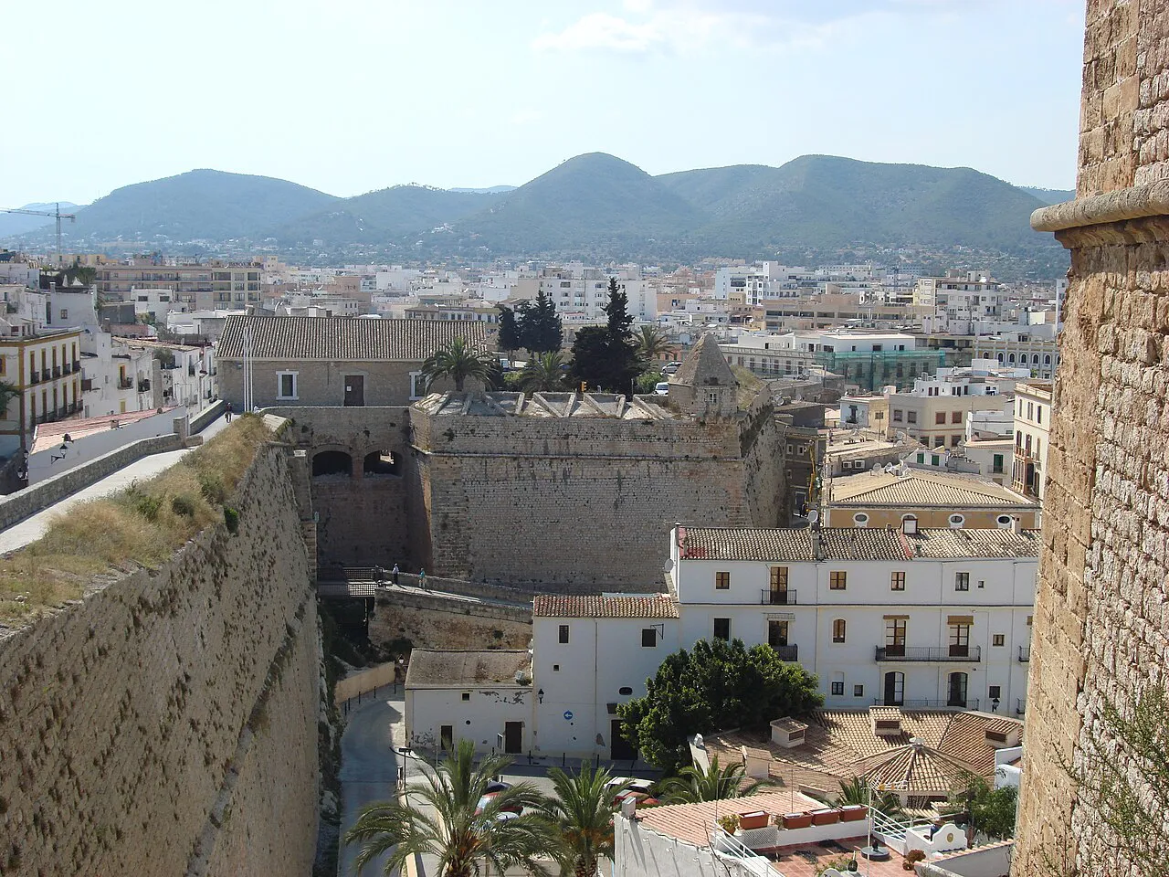 View from the Dalt Vila ramparts over Ibiza Town's rooftops and fortifications to green hills