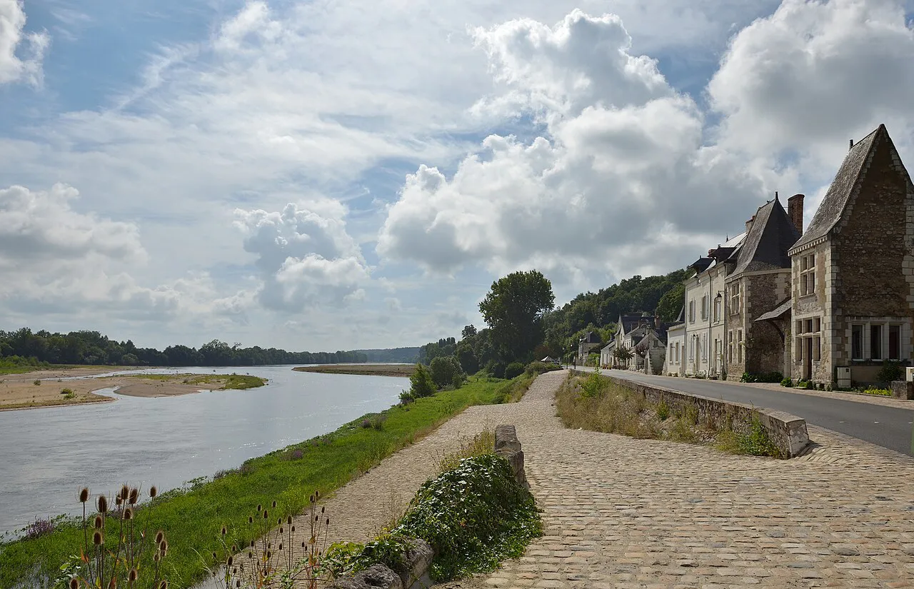 Cobbled riverside path beside the wide Loire at Chênehutte-Trèves-Cunault, with stone village houses