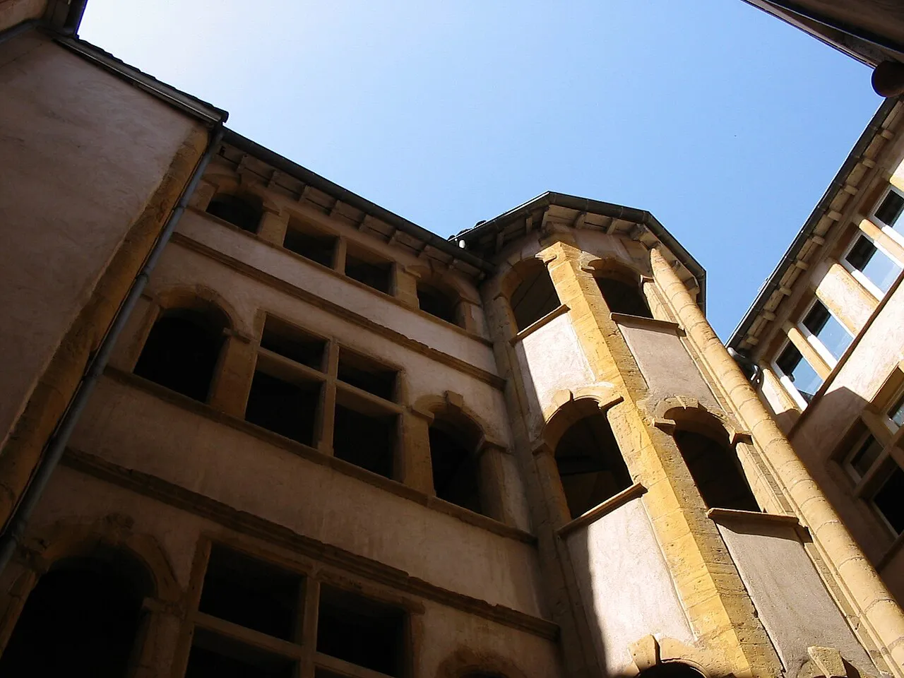 Looking up at a Renaissance courtyard and spiral stair tower inside a Lyon traboule