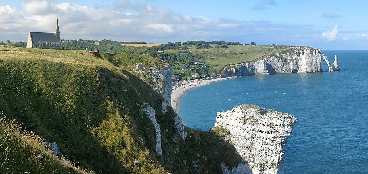 Notre-Dame-de-la-Garde chapel on the clifftop above Étretat, with white chalk cliffs and blue sea