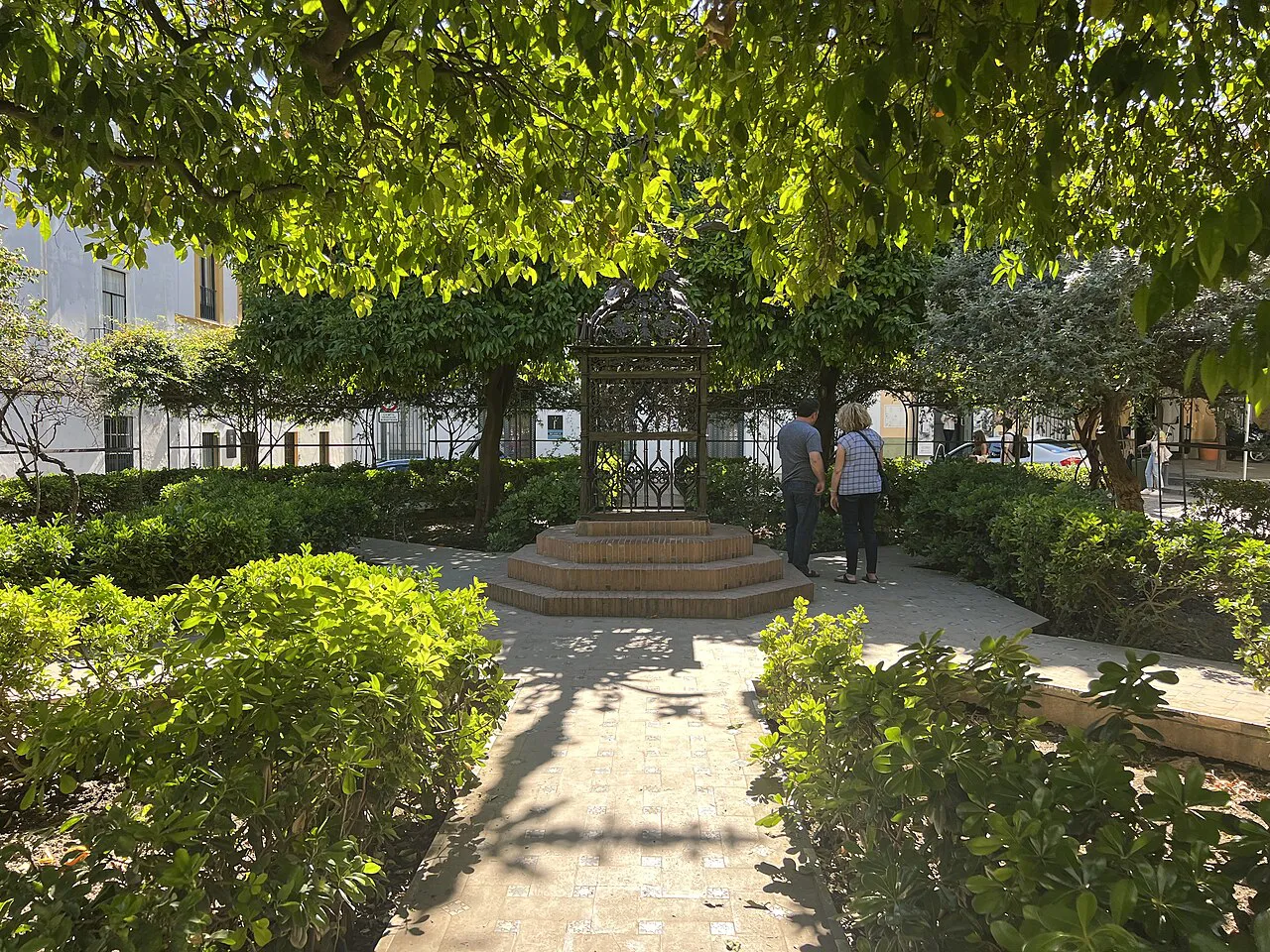 Shaded garden paths and an iron cross in Plaza de Santa Cruz, Barrio Santa Cruz, Seville