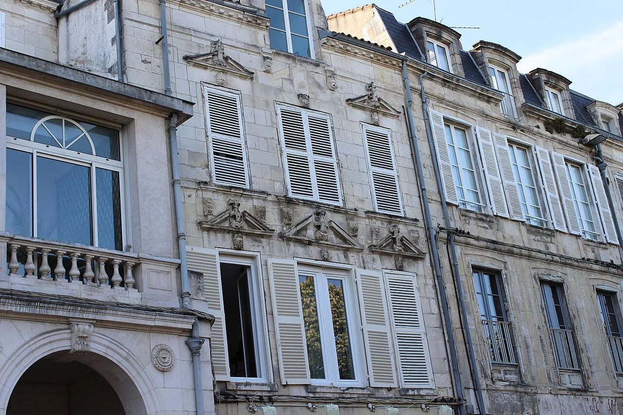 Shuttered pale-stone facades with carved window details on the Cours des Dames in La Rochelle