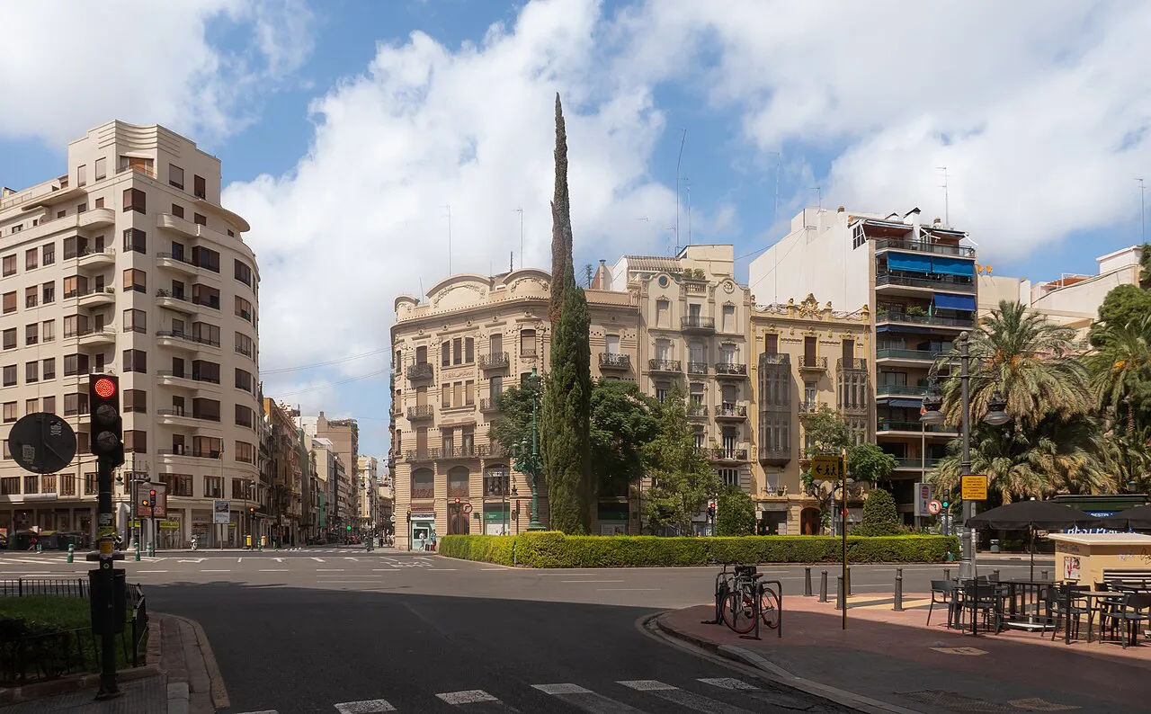 Street corner in Valencia's Ruzafa and Eixample area with period apartment blocks, a cypress and palms