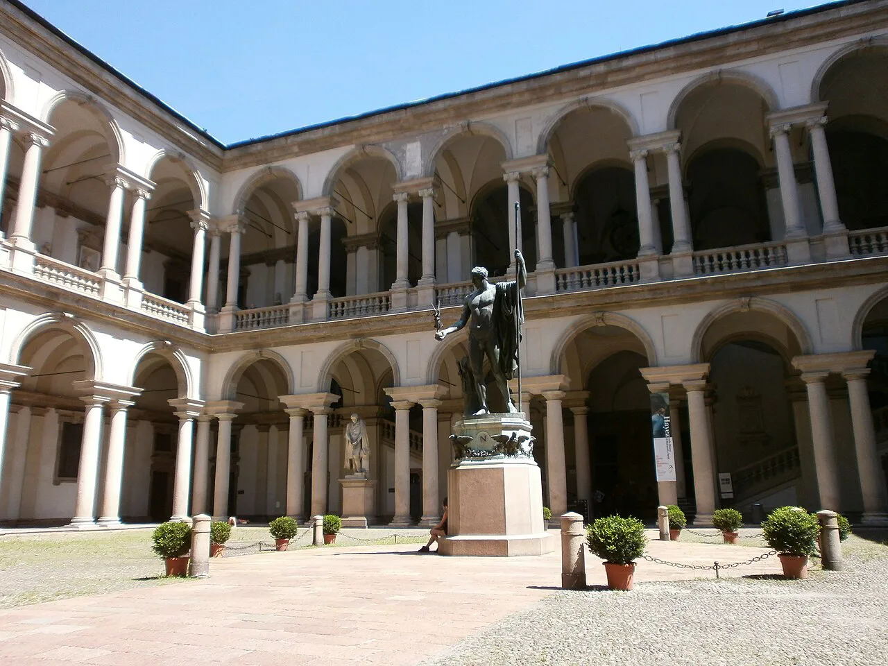Two-tier arcaded courtyard of Palazzo Brera in Milan with a bronze statue at its centre