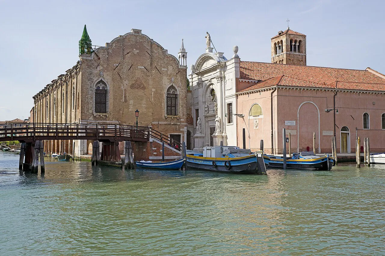 Wooden bridge and moored boats before the Abbazia della Misericordia in Cannaregio, Venice