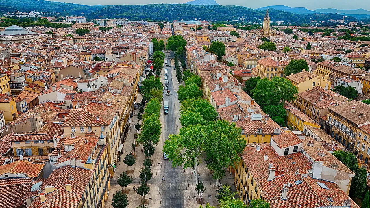 Aerial view of the tree-lined Cours Mirabeau cutting through the terracotta rooftops of Aix-en-Provence