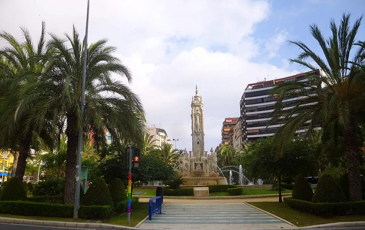 Palm-framed Plaza de los Luceros in Alicante with its tall central fountain monument