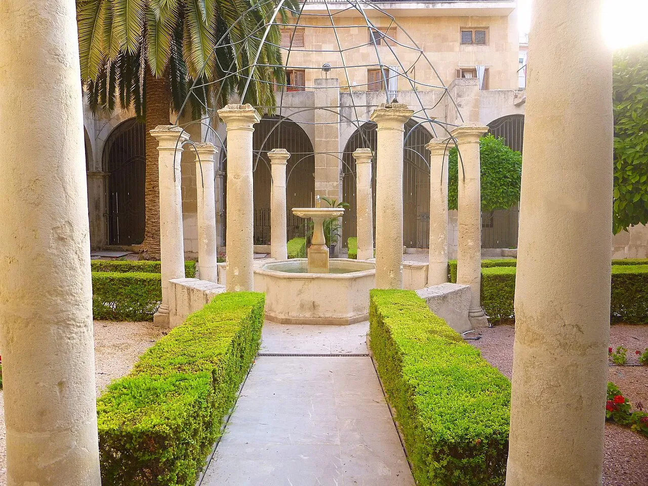 Arcaded cloister garden with clipped hedges and a fountain at Alicante's Co-Cathedral of San Nicolás