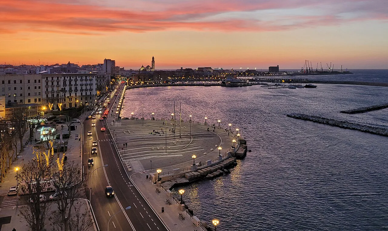 Lungomare Araldo di Crollalanza curving along the sea in Bari under a vivid orange sunset sky