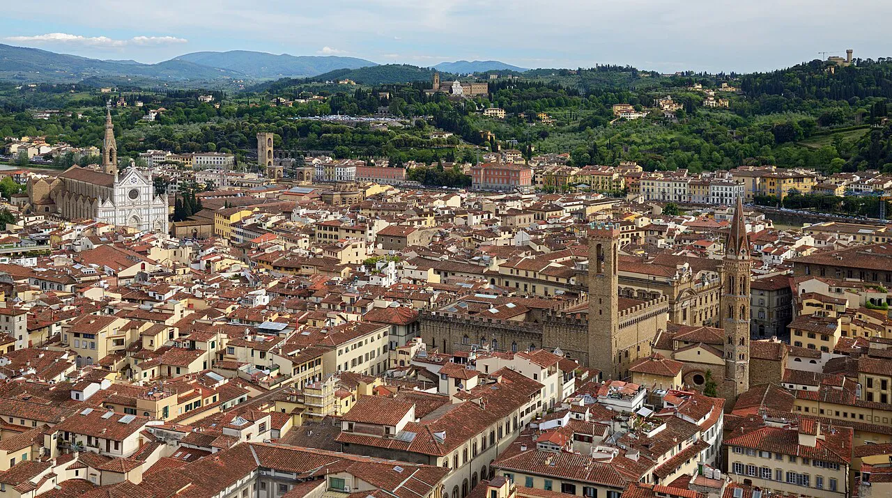 Terracotta rooftops of Florence toward Santa Croce and the green hills, seen from Giotto's Bell Tower
