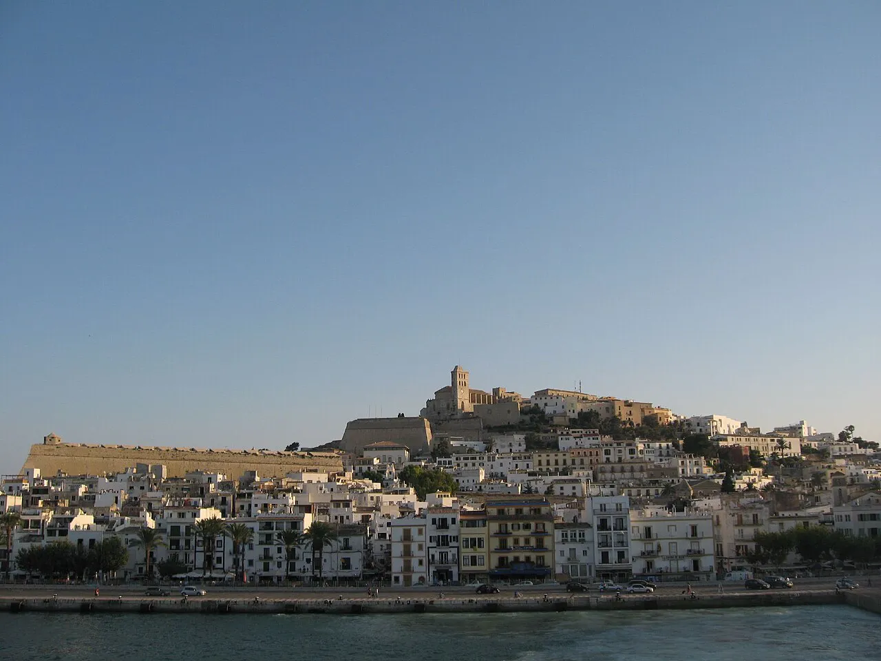 The walled old town of Dalt Vila rising above the harbourfront of Ibiza Town in evening light