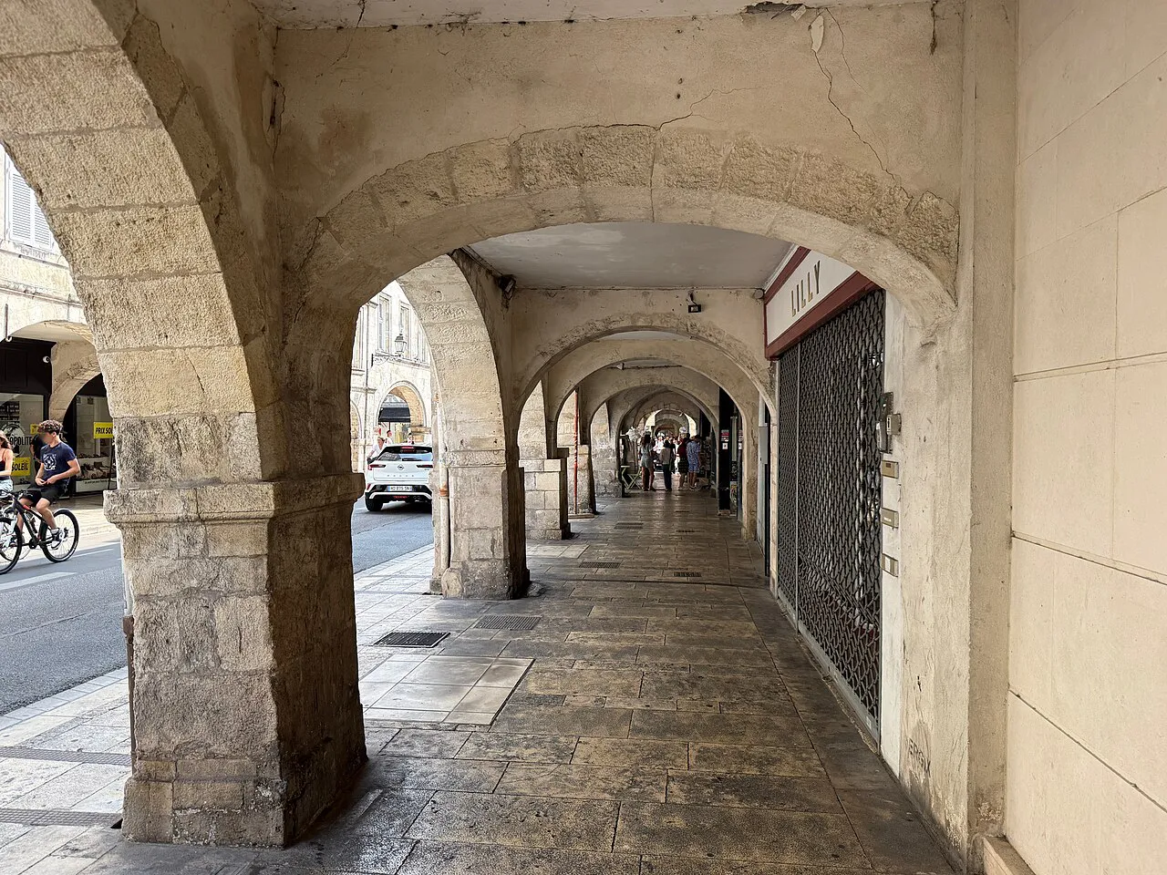 Stone arcades sheltering the pavement along Rue Chaudrier in La Rochelle’s old town