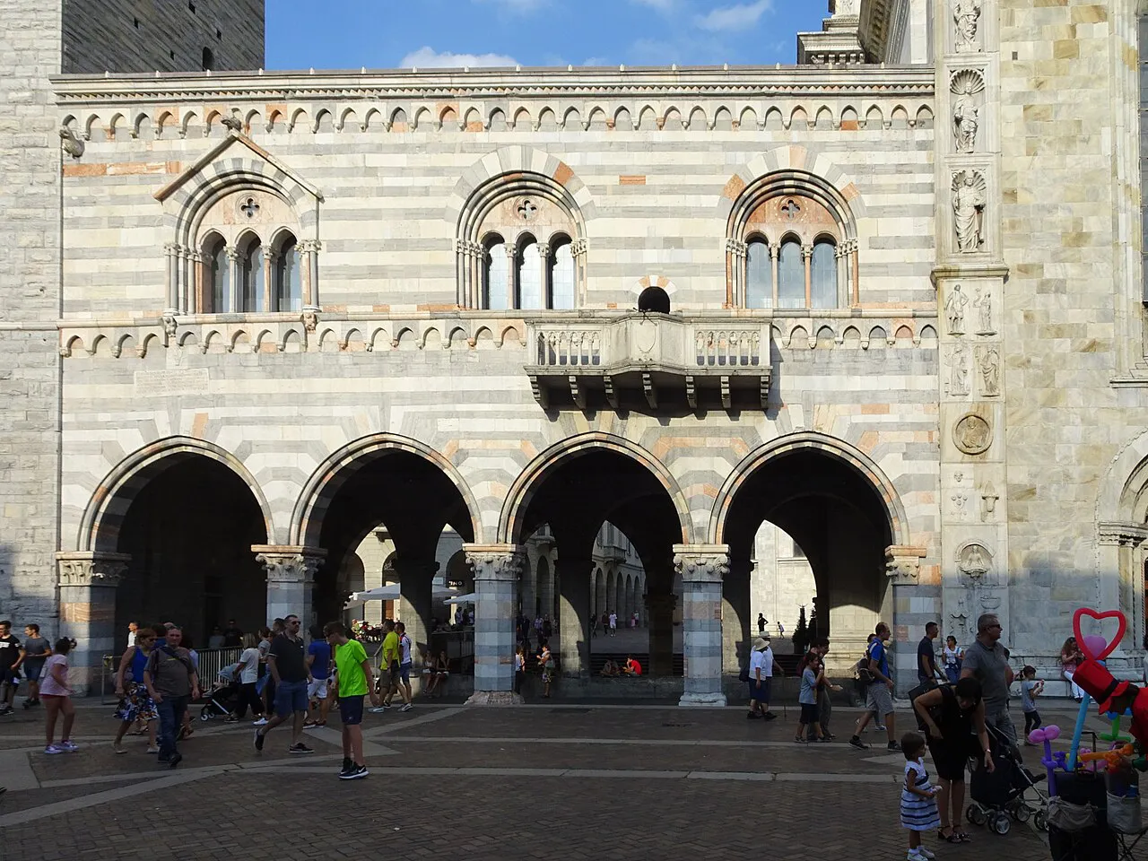 Striped marble arcades and windows of the medieval Broletto beside Como Cathedral