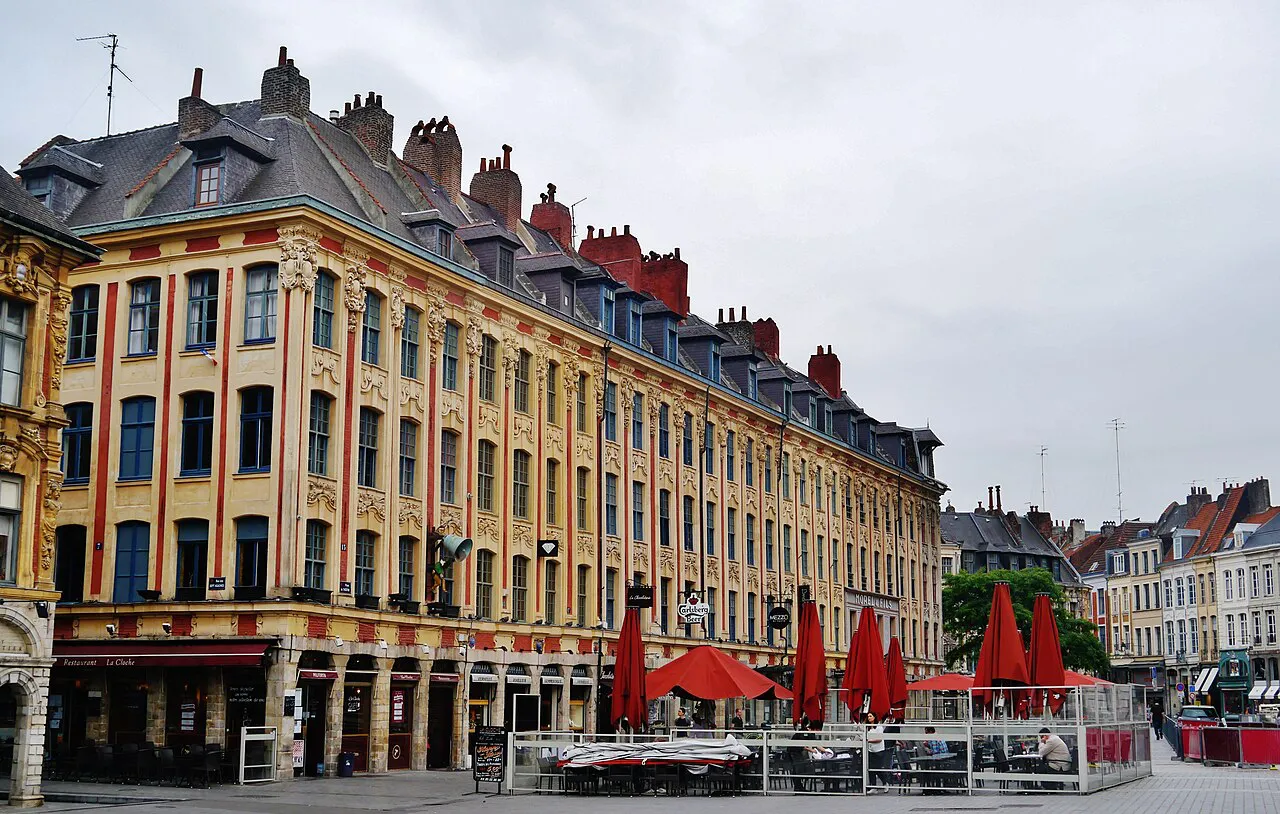 Rows of Flemish-style brick facades with café umbrellas on Place du Théâtre, Lille