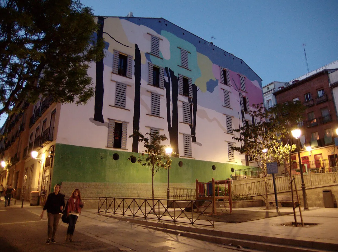 Mural-covered building on a square in the Lavapiés neighbourhood of Madrid at dusk