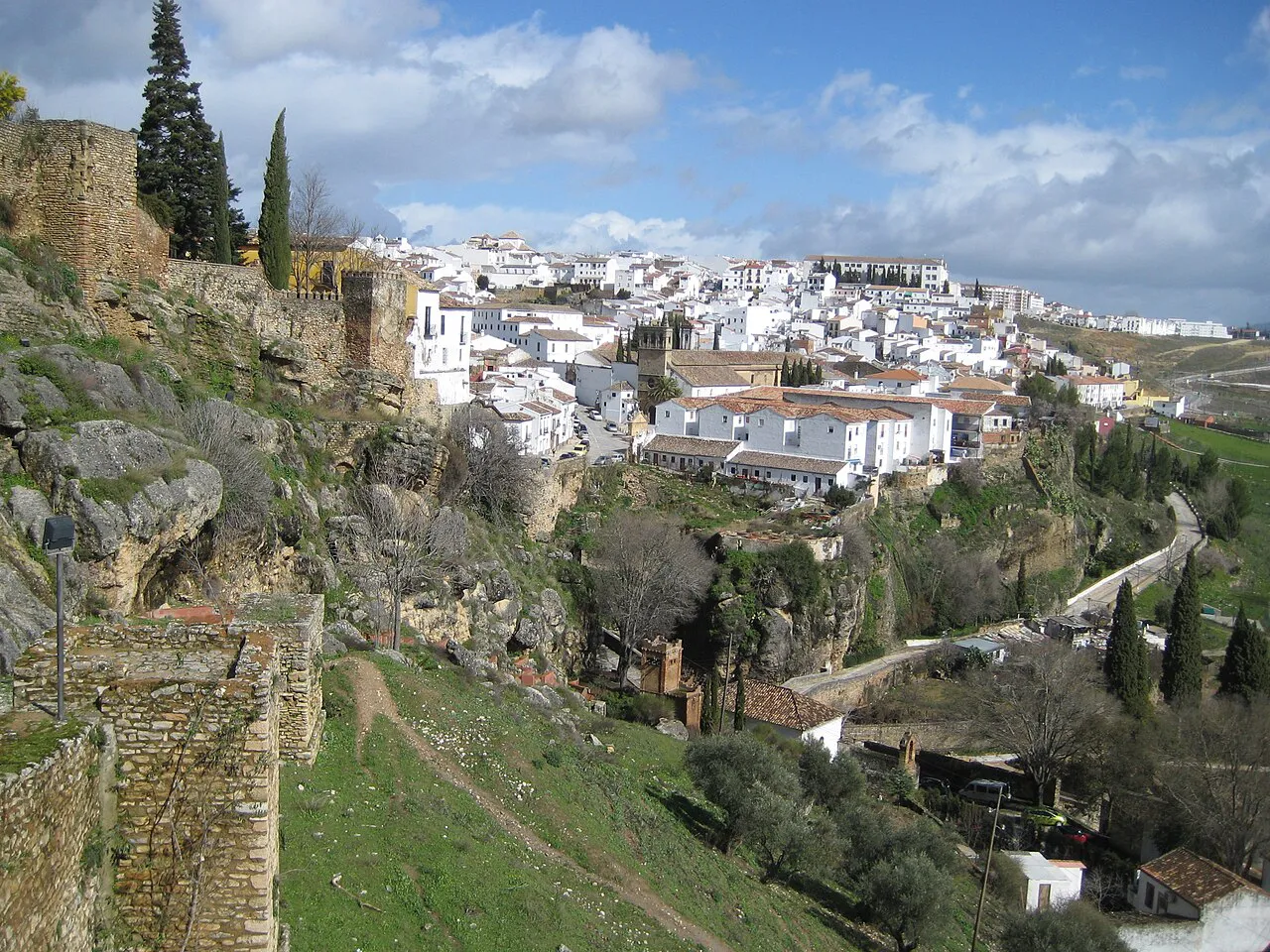 Whitewashed houses of Ronda's newer town spread along the ridge, seen from the old city walls
